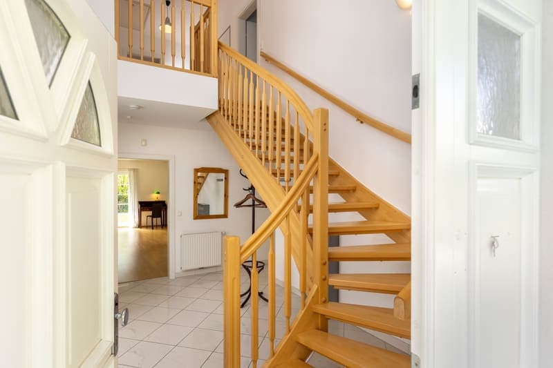 Eingangsdiele mit Holztreppe und Marmorboden