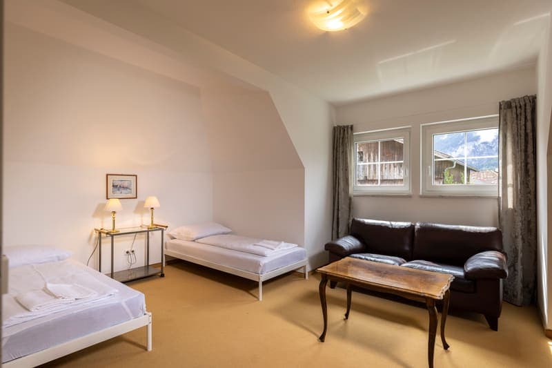 Dachgeschoss-Schlafraum mit Sitzecke und Bergblick